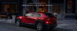 Red 2020 Mazda CX-30 parked in front of a nice restaurant with a few people on the sidewalk. | Mazda dealer in Ellisville, MO