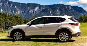 White Mazda CX-5 parked with  mountains  with greenery and trees in the background. | Mazda dealer in Ellisville, MO