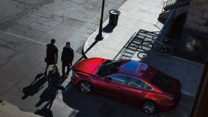 Red 2020 Mazda6 parked beside a sidewalk with pedestrians crossing the street in front of it. | Mazda dealer in Ellisville, MO