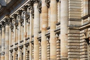 The side of a tall building with old, very detailed architecture.