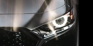 Close up view of the driver side beaming headlight of a silver 2020 Mazda3 sedan. | Mazda dealer in Ellisville, MO